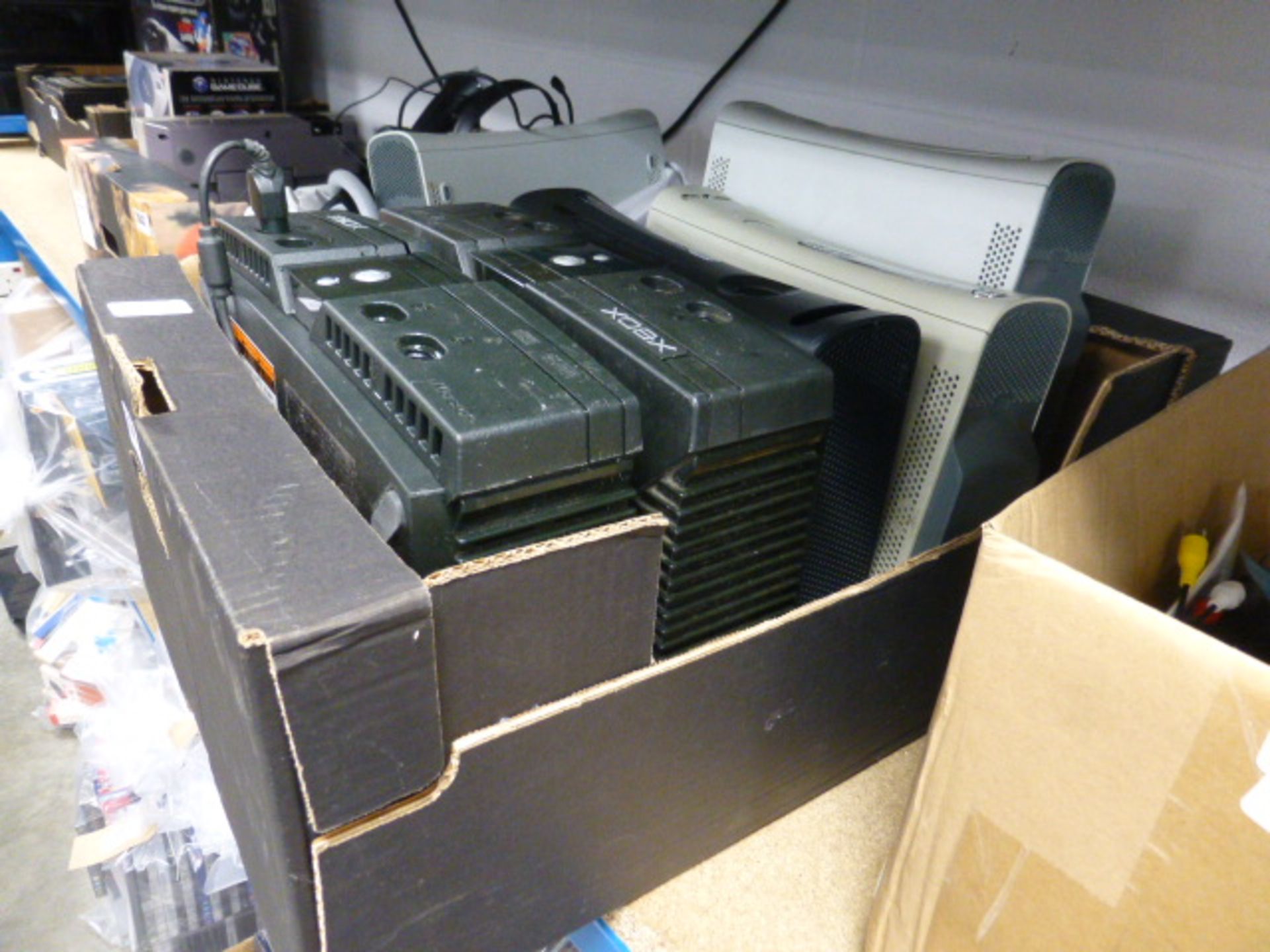 Cardboard tray containing X Box 360 and classic X Box consoles