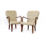 A pair of 1950/60's button upholstered armchairs with shaped beech arms and square tapering feet,