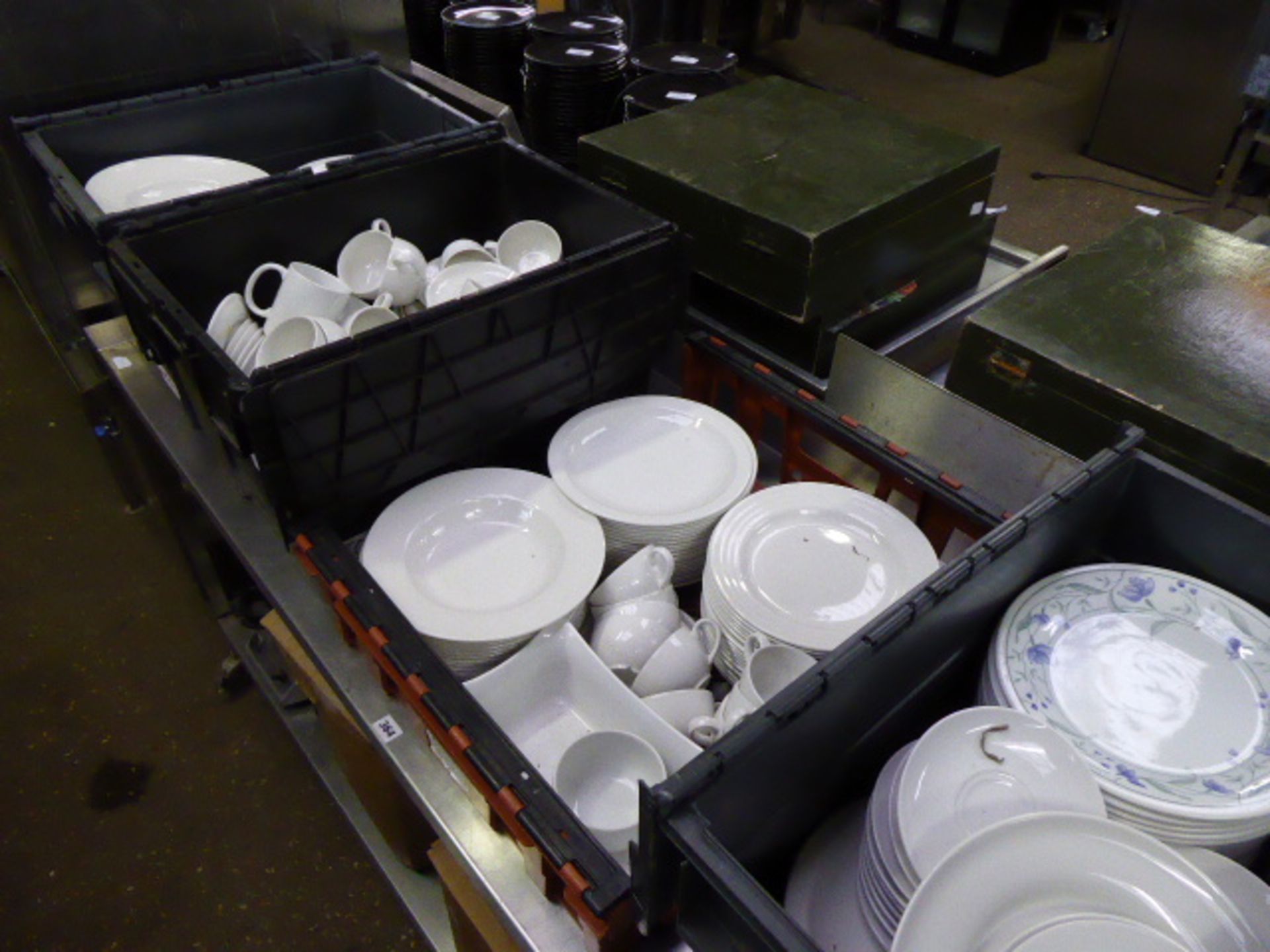 4 large plastic stacking crates containing mainly white crockery to include cups, saucers, dinner