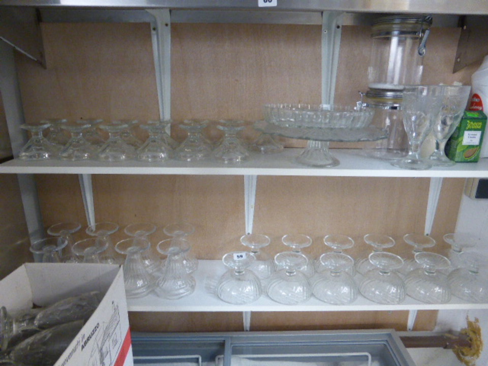 Two shelves of glass ice cream dishes plus two boxes of other dishes