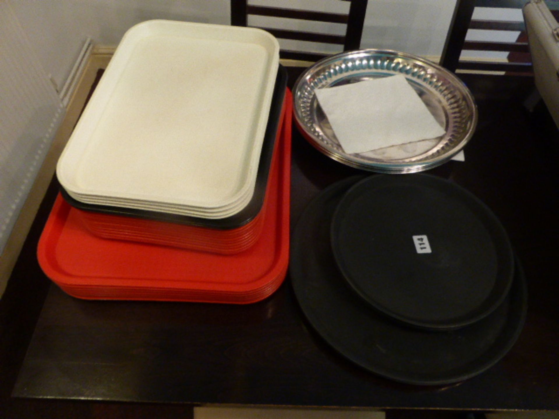 Stack of plastic rectangular trays, round rubberised trays, plus round metal trays