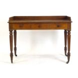 A late 19th century mahogany writing table with a galleried surface over three frieze drawers,
