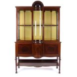 A late 19th/early 20th century mahogany and strung display cabinet surmounted by a shell-type