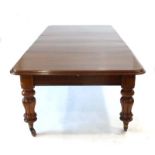 A Victorian oak extending dining table, with three fitted leaves, on turned supports with castors,