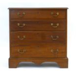 A reproduction mahogany and stained oak bachelors-type chest of four long graduated drawers on