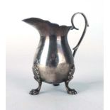 An early 20th century silver cream jug of typical form with c-scroll handle on three paw feet,
