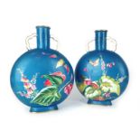 A pair of Aesthetic Movement moon flasks decorated with butterflies and foxgloves on a kingfisher