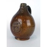 A Martin Brothers terracotta bellarmine jug decorated in a plain treacle glaze, inscribed to base,