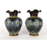 A pair of Doulton Lambeth vases of baluster form relief decorated with stylised flowerheads on a