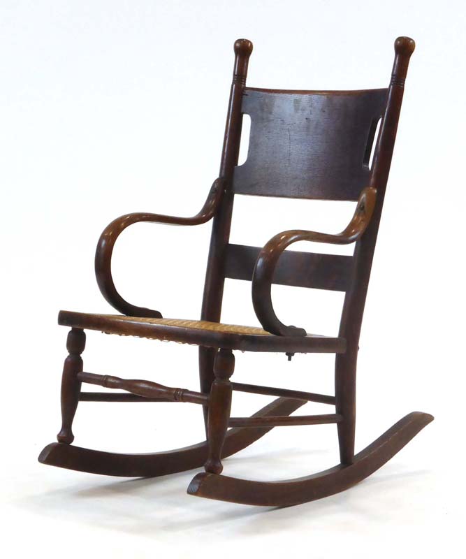 A late 19th/early 20th century oak child's rocking chair with bentwood arms and a bergere seat