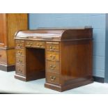 A late 19th century mahogany rolltop desk with a brass gallery over an arrangement of nine drawers