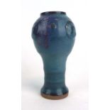 A terracotta studio pottery vase of mallet form decorated in a plain blue glaze, h. 17.