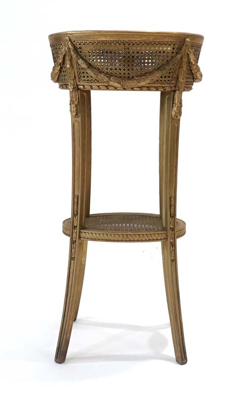 A 19th century gilt plant stand with bergere side panels and swag decoration on splayed legs