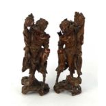 A pair of Chinese hardwood figures each modelled as a gentleman taking tea from a teapot,