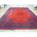 A 20th century woollen rug, the red ground with blue floral borders,