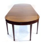 A Georgian mahogany dining table, including a central drop-leaf section,