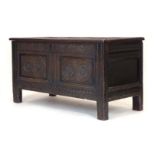 An 18th century carved oak panelled coffer on square straight stiles, l.