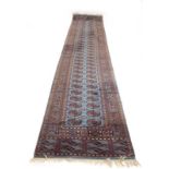 A 20th century woolen runner, the blue ground with a Tekke-type pattern within matching bands,