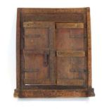 A pair of Eastern carved hardwood doors with cast metal brackets, fitted into a matching surround,