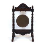 A late Victorian dinner gong with a carved oak frame, h.