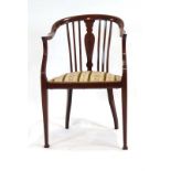 An Edwardian mahogany and strung parlour armchair with an upholstered seat,