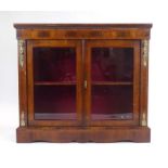 A 19th century walnut and strung pier cabinet, the pair of glazed doors enclosing a single shelf,