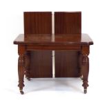 A Victorian mahogany extending dining table on turned legs with castors, with two fitted leaves,