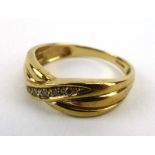 A 9ct yellow gold crossover ring set five small cinnamon diamonds, ring size O, 2.