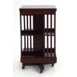 An Edwardian walnut, crossbanded and marquetry revolving bookcase, h.