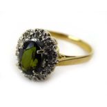 An 18ct yellow gold cluster ring set oval tourmaline within a diamond set border, ring size N, 3.