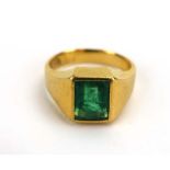 A Chinese yellow metal ring set baguette cut emerald in a rubover setting, ring size K, 7.