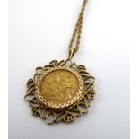 A 9ct yellow gold ropetwist necklace suspending a yellow metal openwork pendant set an Edwardian