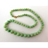 A graduated pale green jade necklace, max d. 9 mm, l. 41.
