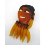 A Josephine Baker bakelite/moulded plastic brooch in the form of a female beauty head and shoulders