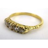 An early 20th century 18ct yellow gold ring set five graduated diamonds in a pierced scrollwork