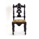 A 19th century figural carved oak side chair with a drop-in seat over a shaped apron on turned legs