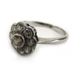 An early 20th century platinum cluster ring set nine diamonds in a flowerhead rubover setting,