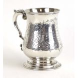 A Victorian silver tankard of bellied form with leaf capped c-scroll handle, maker RH, London 1863,