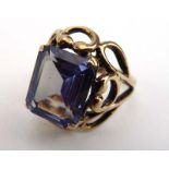 A 9ct yellow gold dress ring set emerald cut alexandrite-type stone in a raised openwork setting,