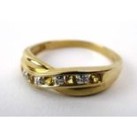 A 9ct yellow gold ring set small diamonds and yellow sapphires in a channel-type twist setting,