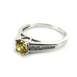 An 18ct white gold ring set fancy yellow brilliant cut diamond in a four claw setting,