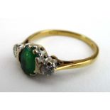 An 18ct yellow gold ring set oval emerald and two small diamonds, ring size N, 2.