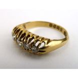 An 18ct yellow gold ring set five graduated diamonds in an openwork setting,