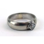 An 18ct white gold band ring set brilliant cut diamond in a rubover diamond shaped setting,
