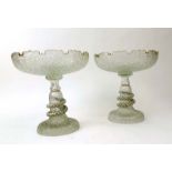 A pair of late 19th/early 20th century clear glass tazzas having moulded leaf decoration and