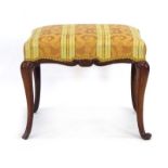A Victorian mahogany and upholstered stool on cabriole legs