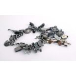 A silver curblink chain suspending a quantity of charms including an enamelled fish, button hooks,