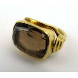 A yellow metal ring of Etruscan design set smoky quartz in a raised knot-type setting, ring size G,