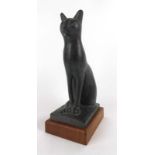 A 1965 Austin Productions figure modelled as a seated cat, on a teak base, h.