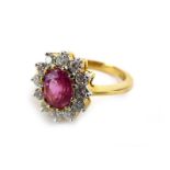 An 18ct yellow gold cluster ring set oval cut Burmese ruby in a surround of twelve brilliant cut